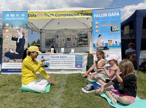 Image for article Inghilterra: La gente impara gli esercizi della Falun Dafa durante il festival del Giorno del villaggio di Ashtead