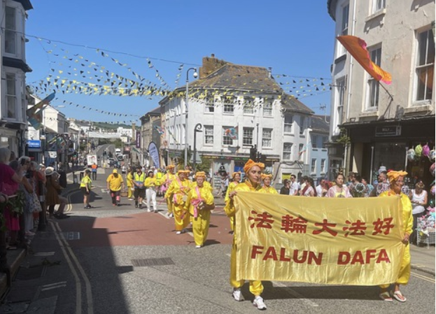 Image for article Penzance, Regno Unito: La squadra dei tamburini della Falun Dafa partecipa alla parata del Festival
