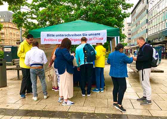 Image for article Germania: La gente sostiene la Falun Dafa durante un evento a Mannheim